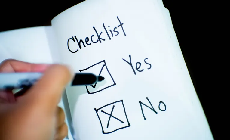 Person marking a checklist representing fact-checking AI answers
