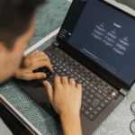 Man typing prompts into an AI chatbot on a laptop
