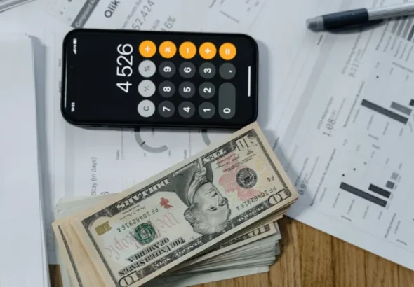 Calculator and financial documents on a desk representing UK invoicing software