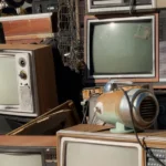 Pile of old televisions and discarded electronics representing planned obsolescence