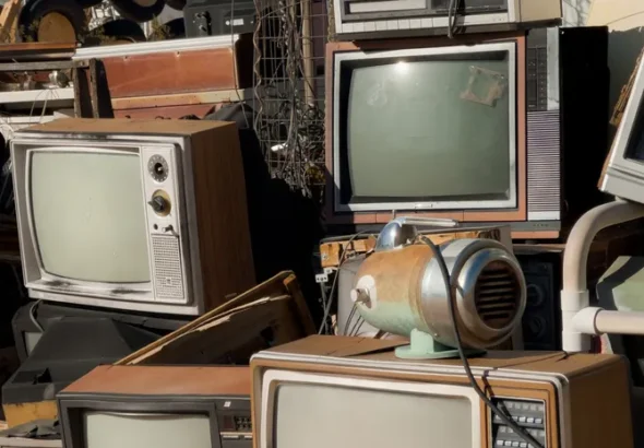 Pile of old televisions and discarded electronics representing planned obsolescence