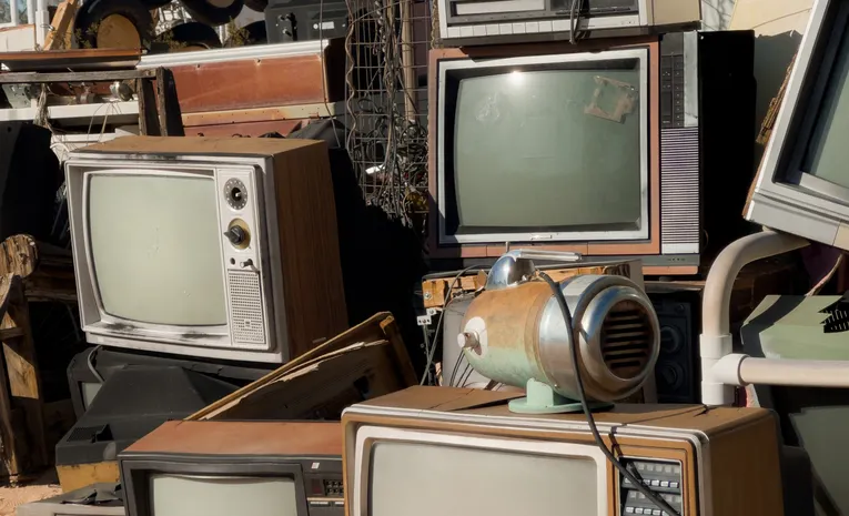Pile of old televisions and discarded electronics representing planned obsolescence