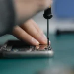 Technician using a screwdriver to repair a smartphone representing right to repair laws