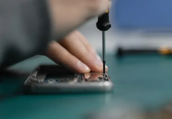 Technician using a screwdriver to repair a smartphone representing right to repair laws