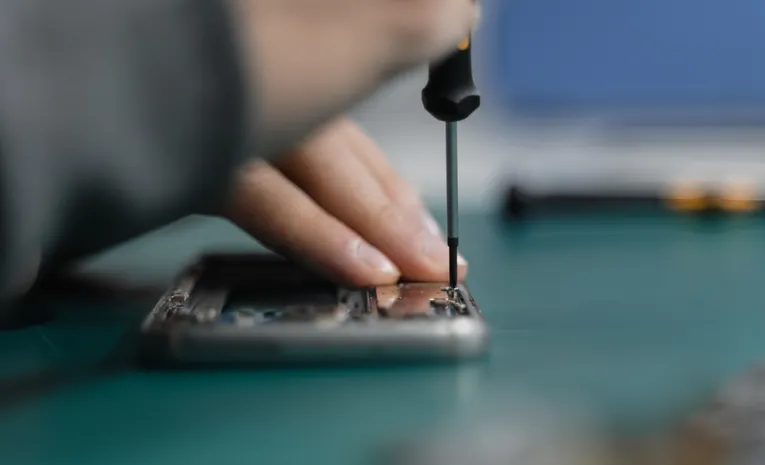Technician using a screwdriver to repair a smartphone representing right to repair laws